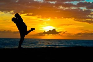 couple hugging at beach with the sunset